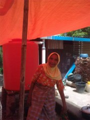 Bright orange water tank Image via Oxfam